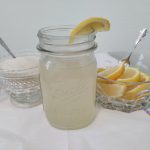 Homemade Lemonade in a mason jar with lemons and sugar next to it