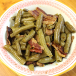 hot green beans with crispy bacon and melted butter in a decorative dish